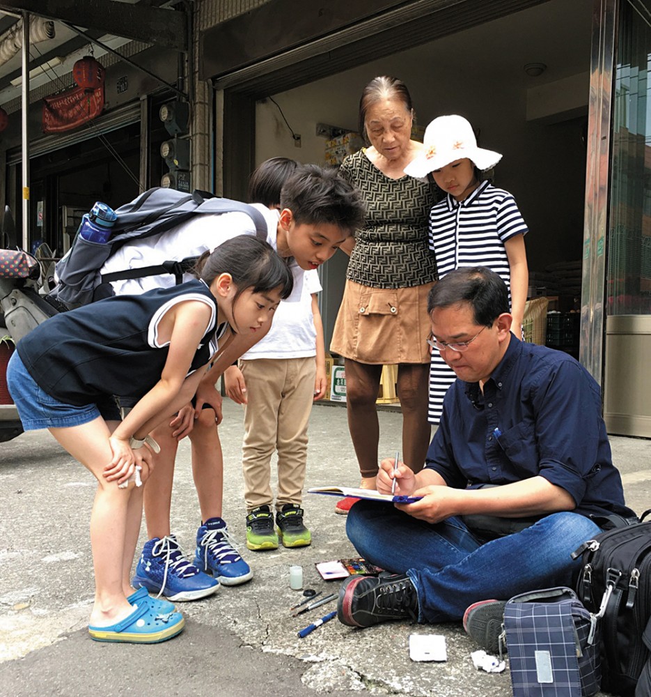 渡邉先生隨地坐下手繪建築時，也吸引不少民眾好奇地圍觀。