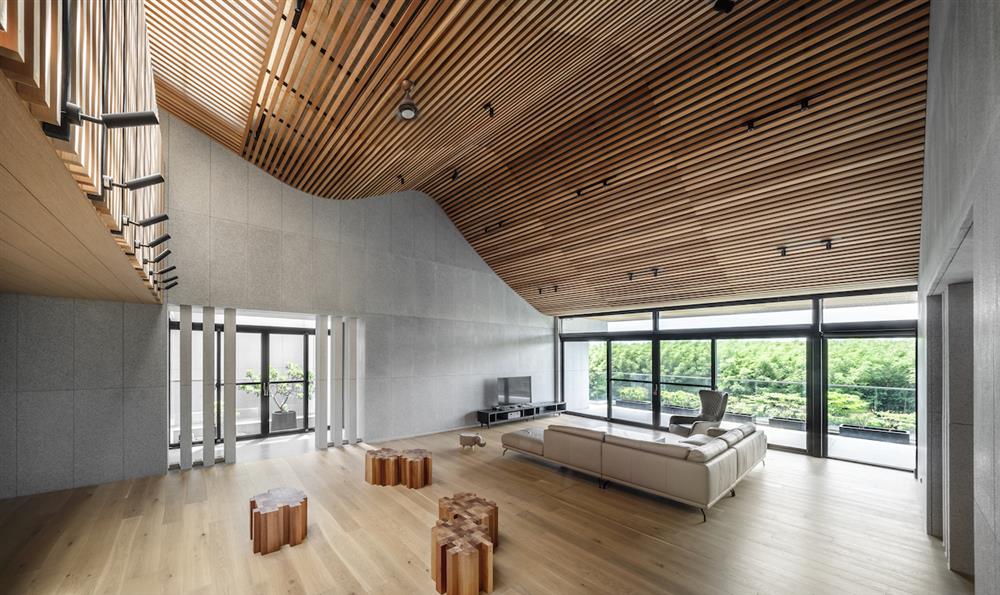 順應捲脊地景及弧形山牆設計的二樓挑高6米客廳，作為家族子孫回鄉齊聚的大廳堂。