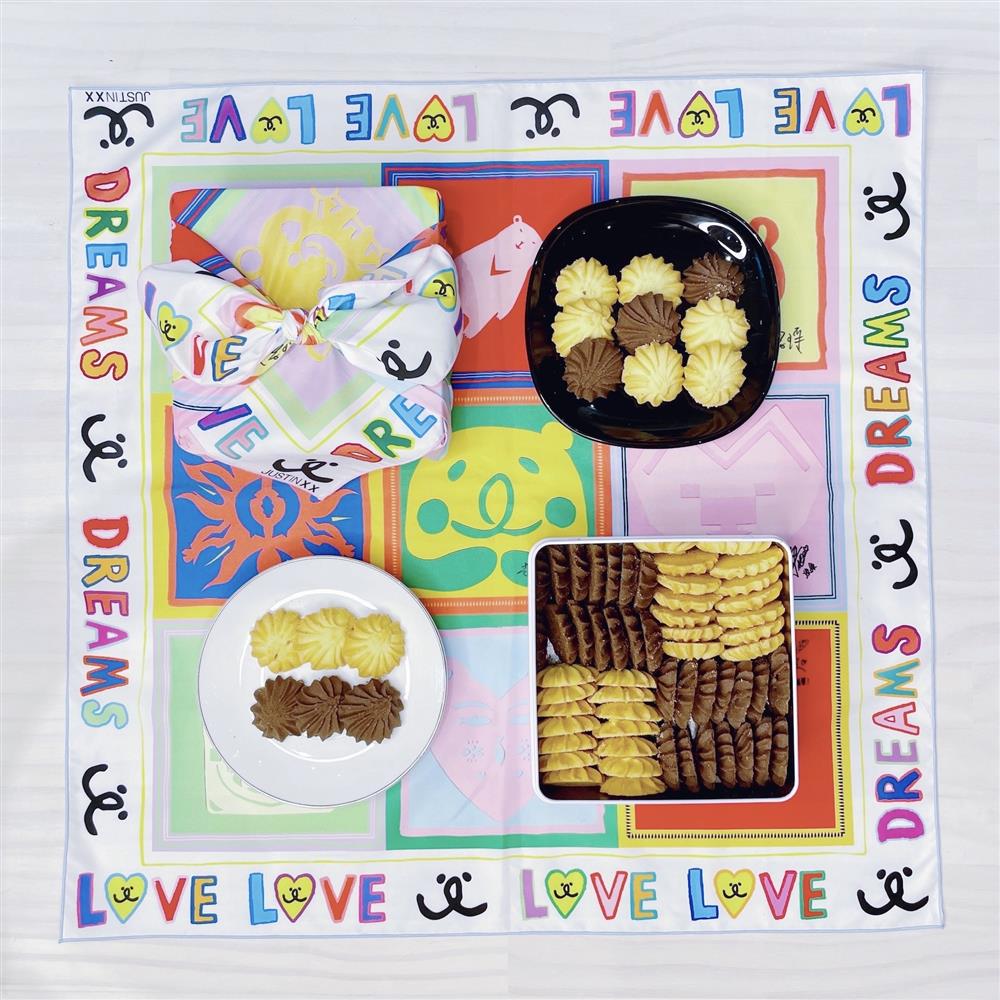 周裕穎藉由包巾取代紙袋包裝的永續時尚理念，為小愉兒基金會設計「永續包巾餅乾禮盒」，期許能幫助小愉兒們募集更多經費，建設夢想家園-2（共推出兩款包巾設計，隨機出貨。）