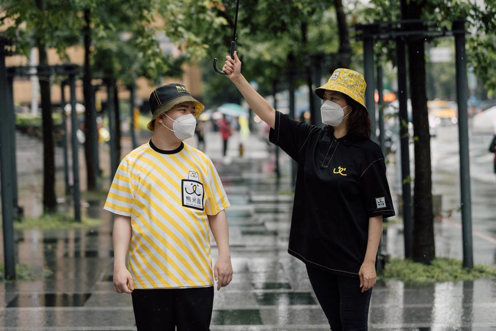 周裕穎以代表小愉兒基金會涵義的微笑、熊與愛心三大元素作為制服設計靈感，攜手剪紙藝術家25度創造剪紙IP，也將基金會小熊LOGO結合黃白條紋展現立體感，為小愉兒基金會創造全新潮流制服。(7)