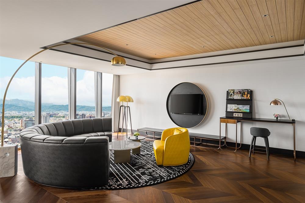 小檔台中李方艾美酒店皇家套房-客廳皇家套房：42.3坪的套房空間，擁有180度無遮蔽遼闊視野，俯瞰台中火車站新舊交織的百年風景以及中央山脈連綿壯麗景觀。獨立的臥室與客廳，由大理石及透明玻璃打造衛浴空間，呈現簡約俐落的時尚質感。