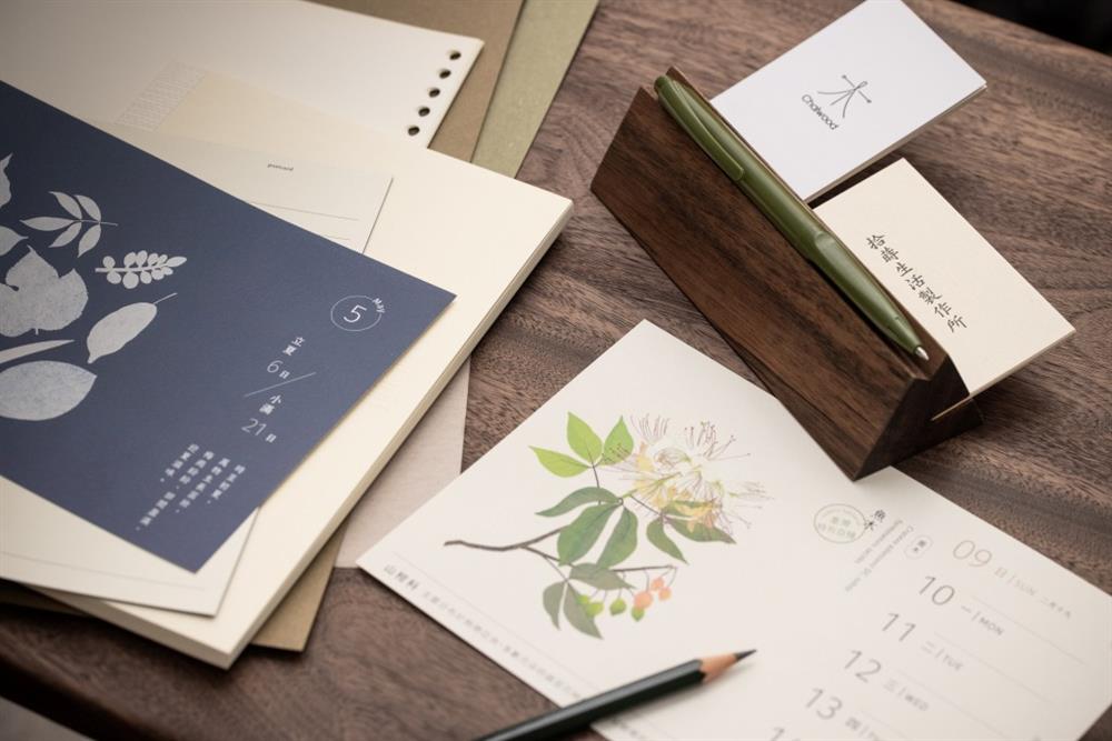 國產相思木山形底座兼具紙鎮、置筆與名片座的複合功能，底座攜手木職人 Chaiwood柴屋和 蛋牌 the egg 合作