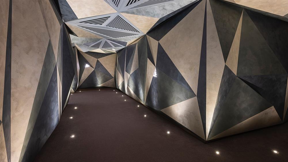 小檔連通大廳與梯廳的通道，以洞穴隧道為意象，穿越其中能身歷其境感受到漫步在山林的感覺