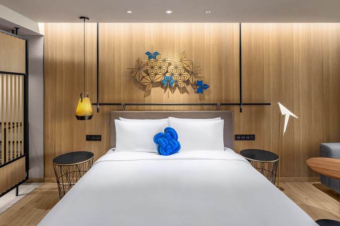 小檔精品房Standard Room-床頭飾板採用楓葉幾何圖形，一旁還有藍鵲燈守護旅人的睡眠