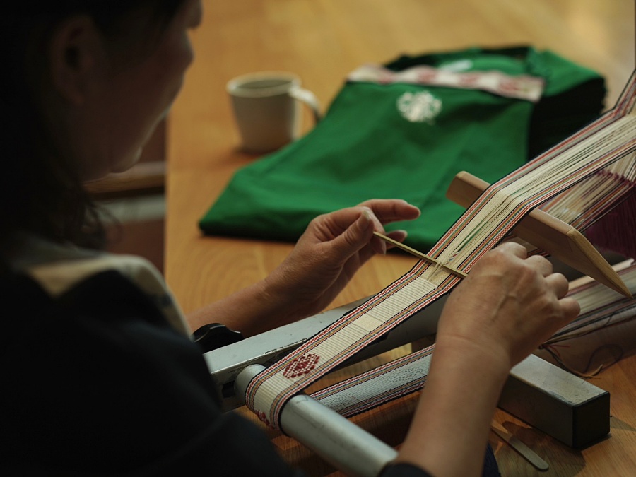 小檔星巴克更透過「財團法人花蓮縣私立和平永續慈善事業基金會」邀請到秀花工坊的石馬秀花老師，以當地最大的部族太魯閣族的文化為靈感來源，協同部落媽媽們編織出太魯閣族以淺色為主，引以為傲的祖靈之眼彩虹橋圖騰，正如同族人對於祖靈之眼的崇敬與信仰，代表著星巴克在地的每一位夥伴們，從人文出發，為每一位來訪的顧客虔誠熱情地獻上一杯咖啡。 (2)