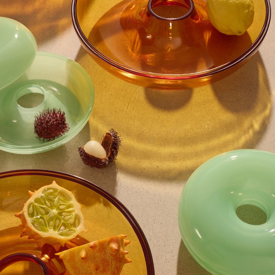 圖六：VARMBLIXT上菜湯碗附蓋，以晶瑩剔透的玻璃製成，搭配彷彿綠落日夕陽的暖橘色、翠綠青草的草地綠，在陽光照射下，更能呈現波光粼粼的美麗景象，打開即可當作兩個碗使用