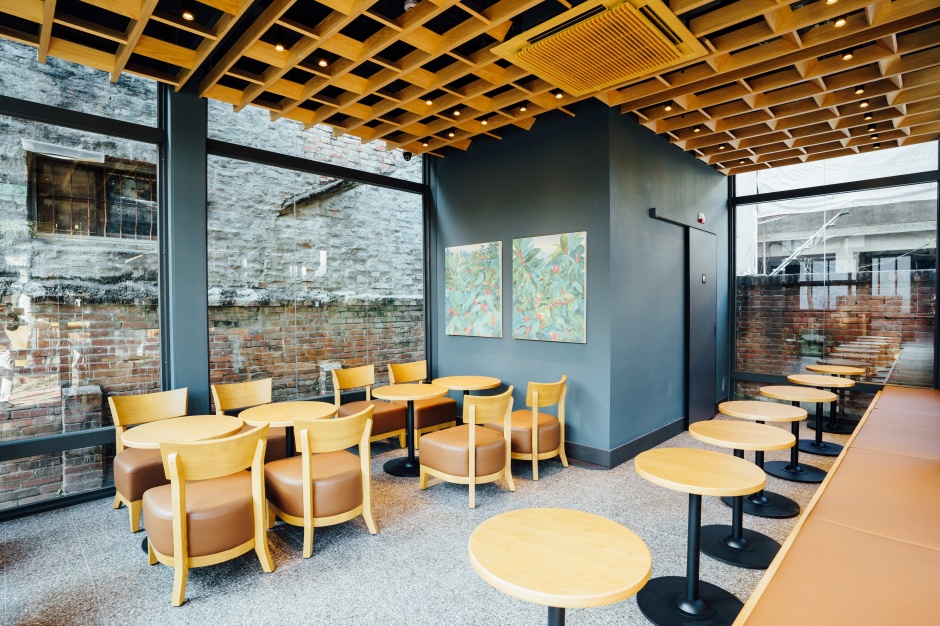 小檔星巴克嘉義新港門市室內採用溫暖的木質和自然的色調，映襯出舊宅磚瓦牆上的青苔和斑駁的痕跡，在在傾訴著它的歷史故事，簡約而樸實的帶出這個宅第當時素樸淡雅的生活景致。 (8)