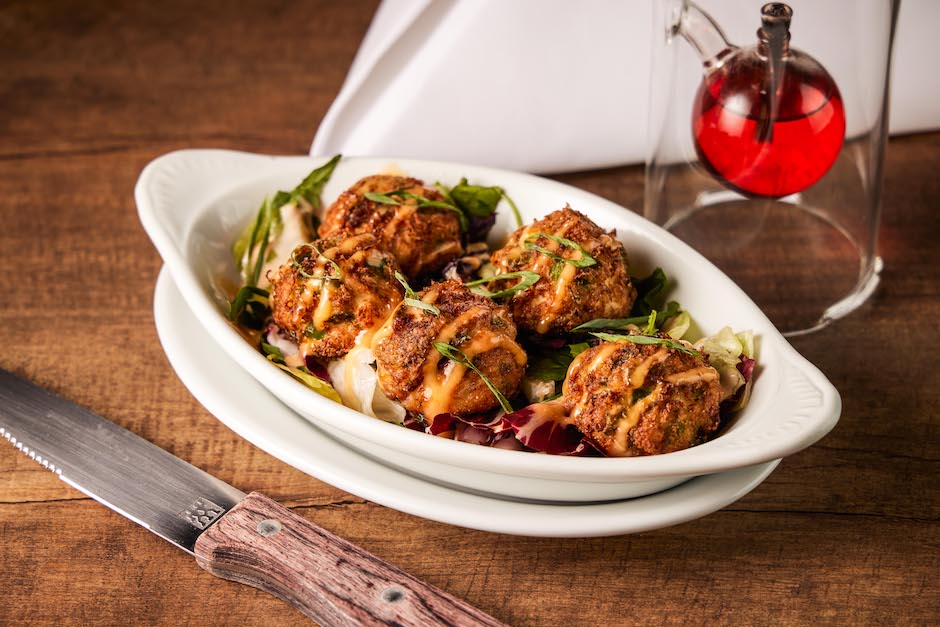 茹絲葵牛排館30週年套餐前菜蟹肉貝涅餅設計概念源自於法國甜甜圈，引進紐奧良大受歡迎後，有別於以往為甜食概念，紐奧良將其改良為鹹食風味！（圖片由茹絲葵提供）