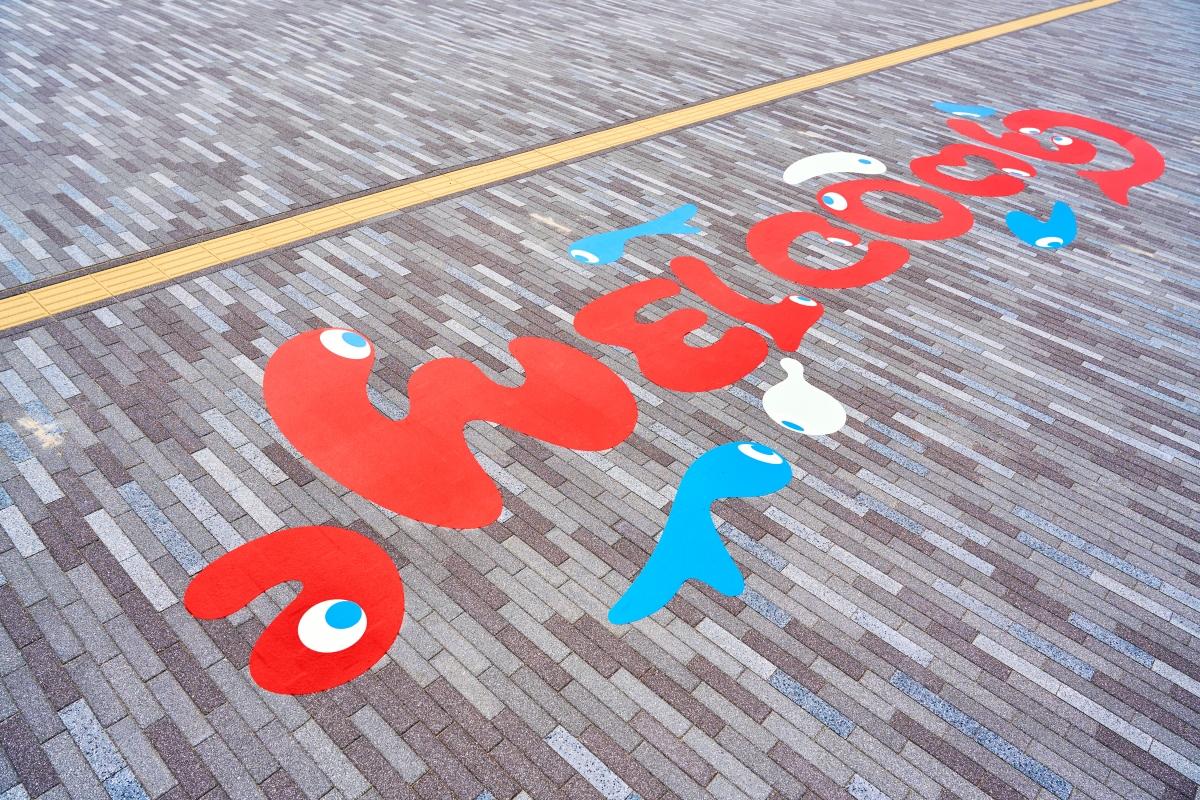 東入口的地面可見「WELCOME」字樣,歡迎旅客到來。(圖片提供:Expo 2025) 東入口的地面可見「WELCOME」字樣,歡迎旅客到來。(圖片提供:Expo 2025)