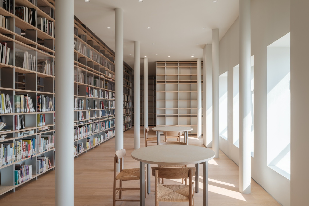 坂本一成操刀的室內設計以溫潤木色書櫃、桌椅等陳設為主體，並有白色樑柱線條點綴其中，兼具現代感與文藝氣息。（圖片提供：Chanel）