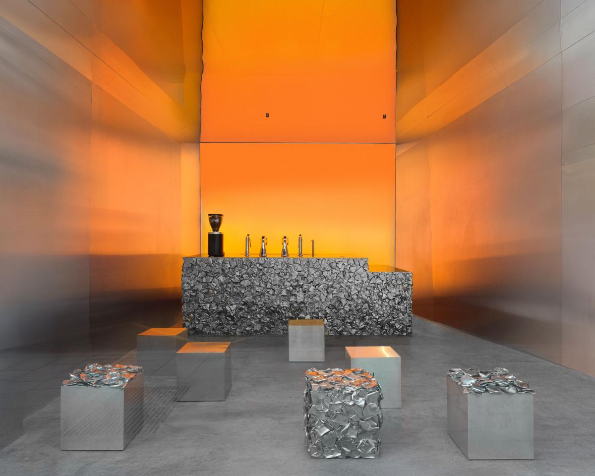 Café Nuances以溫暖的橘色光暈為基調，覆以碎銀金屬的吧台與單張椅凳則是空間中唯一被強調的視覺元素。（圖片提供：Crosby Studios）