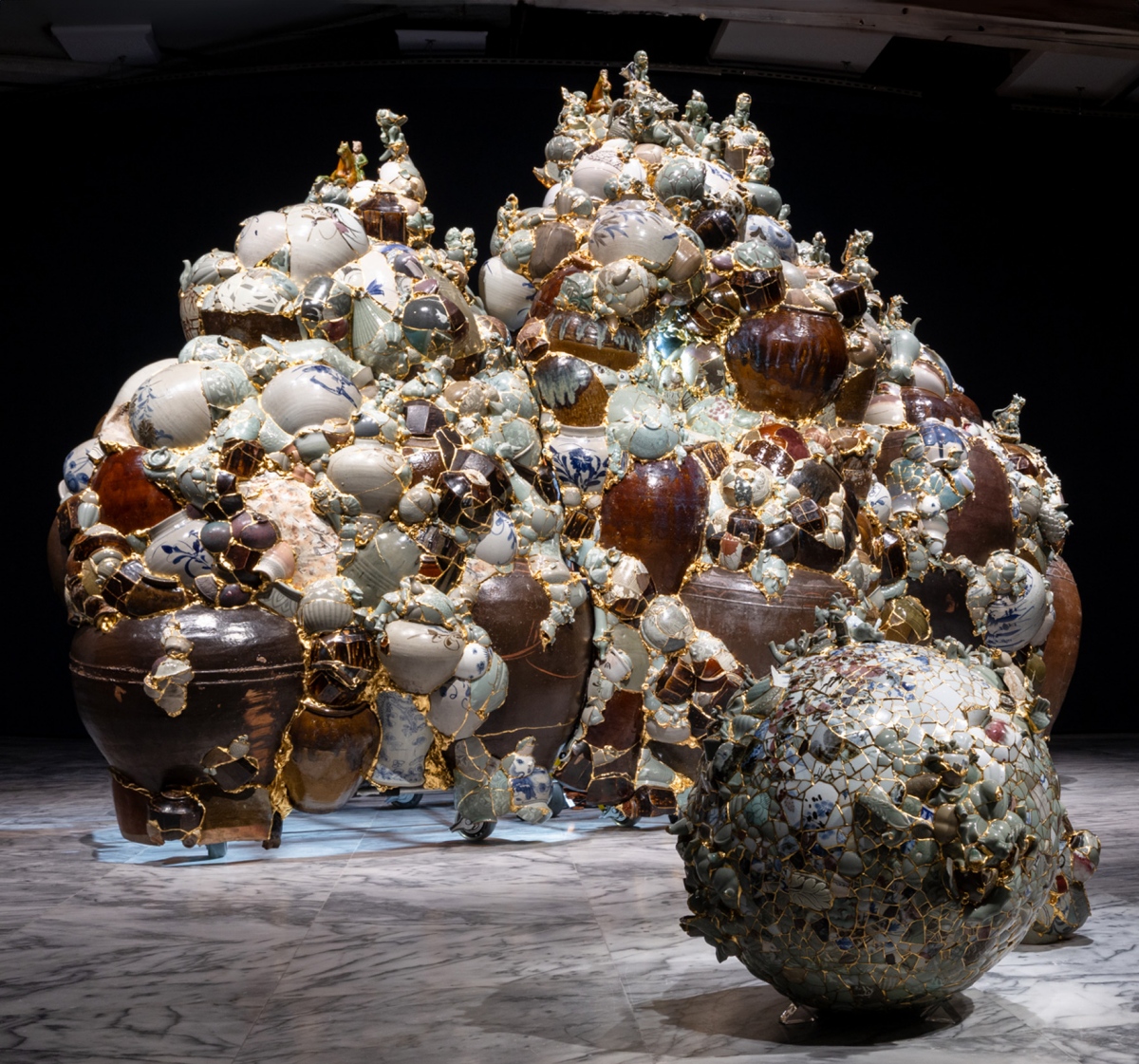 李受俓，《轉譯瓷瓶_ 何時再見_2025》，2025，陶瓷碎片、鋼、環氧樹脂、24K 金箔、燈光，275（高） × 387 ×155 公分 ，藝術家版權所有，由 2025 台北雙年展委託製作。（圖片提供：北美館，攝影：呂國瑋）