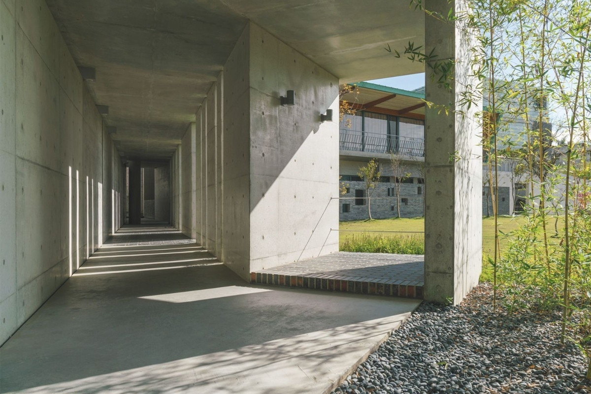 以長廊連綴的建築群全採清水模打造，形成與山林景致交融的灰色帶狀空間。（圖片提供：毓繡美術館）