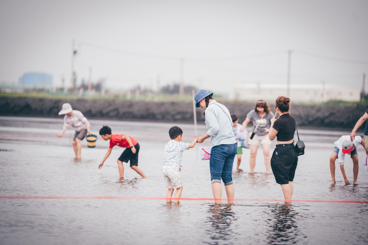 在微風午後的下午場，參與者將踏入這片黑色大地，展開一場回歸自然的物產之旅。親身走入魚塭「摸蜆兼洗褲」的體驗。（圖片提供：風灣的船）